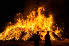 People celebrate St John's Eve (Sant Joan) around a bonfire in a beach of Estartit, Costa Brava, Catalonia, Spain. St John's eve celebration around a bonfire is reminiscent of Midsummer's pagan rituals.